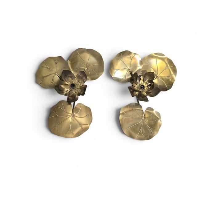 Elegant pair of Maison Jansen style wall sconces dating from the 1970s, crafted in gilt brass and decorated with...