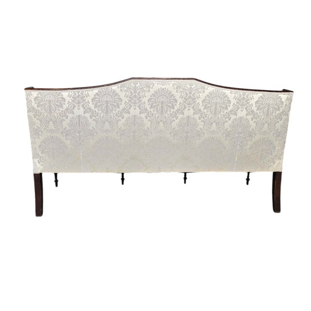 This graceful settee whispers of another time, its serpentine crest rising and falling like a soft sigh across the back....