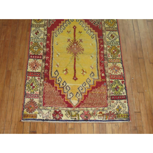 A mid-20th century geometric Turkish runner featuring bright colors with one medallion in an electric blue color. The...