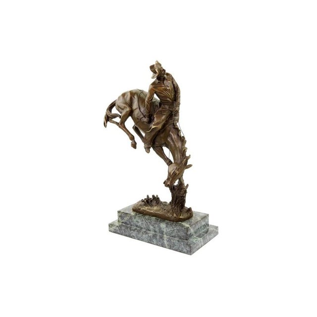 Western bronze cowboy on horse sculpture inspired by Frederic Remington. This bronze piece depicts a cowboy riding a...