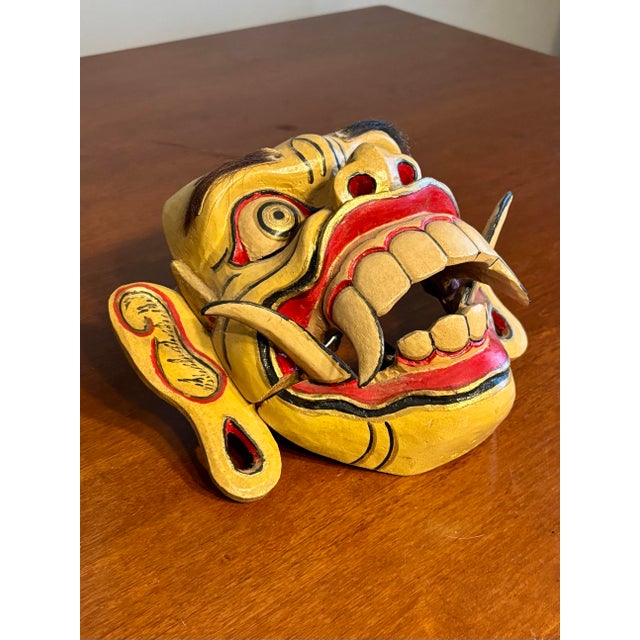 This striking hand-carved Balinese demon mask is an authentic example of traditional Indonesian ritual craftsmanship,...