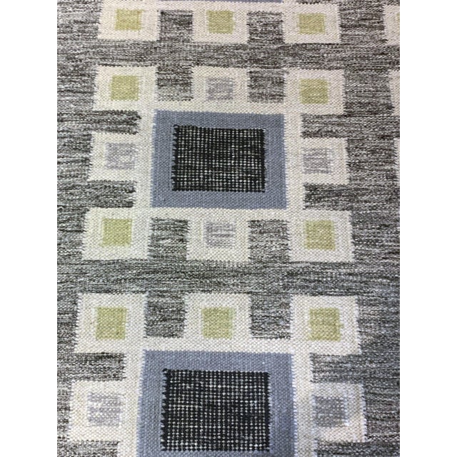 This hand-crafted contemporary Scandinavian-style wool rug features a gray base adorned with an all-over geometric...