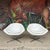 Pair of mid-century modern swivel chairs by Overman. These chairs feature a white vinyl and chrome bases. There is an...