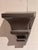 Pair of metal wall brackets with molded shelf tops over tapered, stepped bodies in a soft pewter gray finish. Priced for...