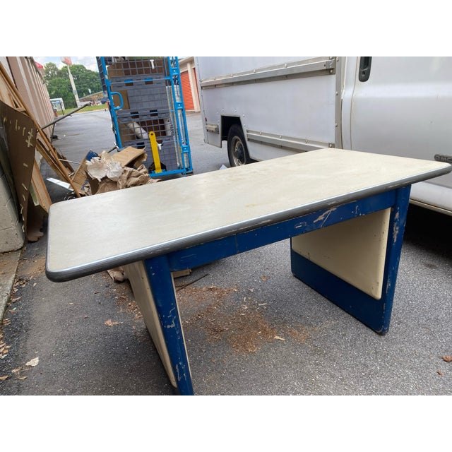 **Description:** Authentic vintage industrial work desk featuring a heavy-duty blue painted steel frame paired with a...