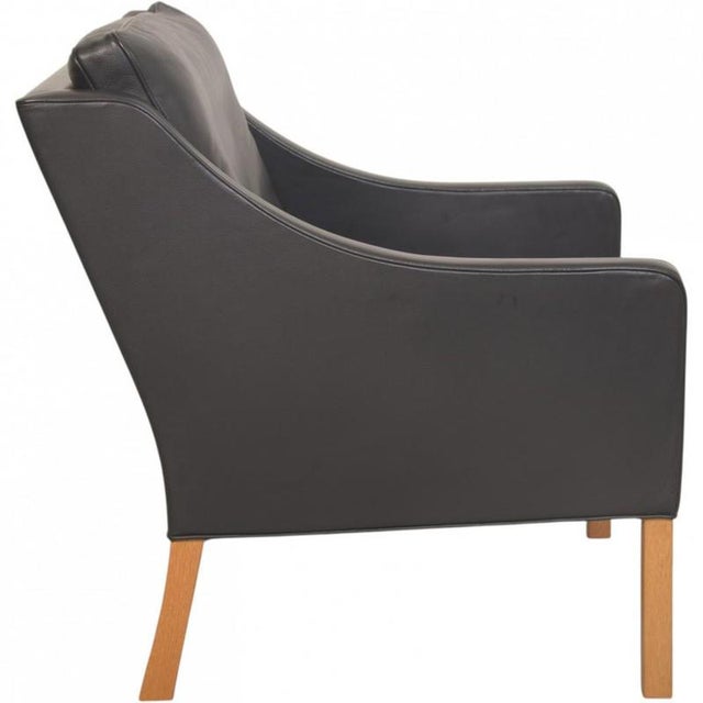 Børge Mogensen lounge chair, model 2207, upholstered in black leather and with legs of oak. The chair is from the 1980s...