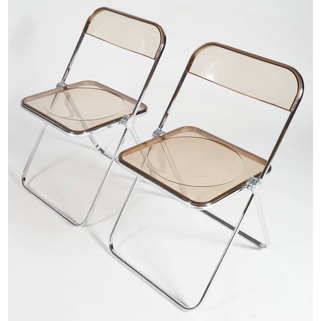 These Giancarlo Piretti for Anonima Castelli Plia Folding Chairs feature a smoky translucent seat and back.