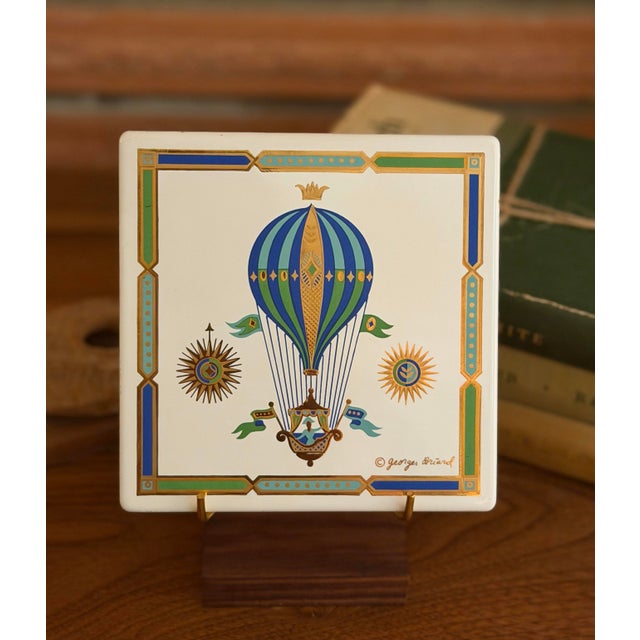 Bring a touch of vintage charm to your home with this original decorative metal tile featuring a colorful hot-air balloon...