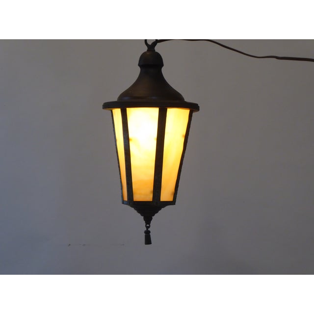 This lantern with verdigris finish has slag glass panels. It ships with the panels removed and packed separately.