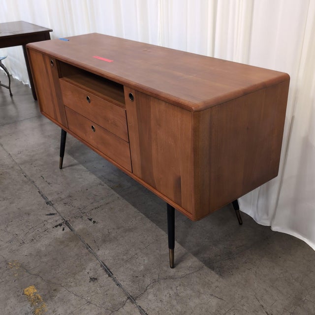 Scandinavian Designs Lanson sideboard in solid poplar with a light walnut stain, black tapered legs, and solid brass foot...