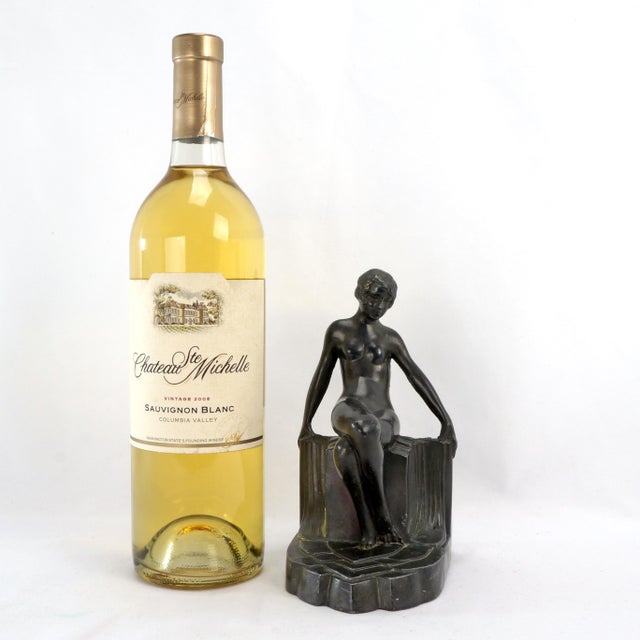 An artistic antique bookend of a nude seated on a plinth that is classic Art Deco. The cast pot metal bookend has a dark...