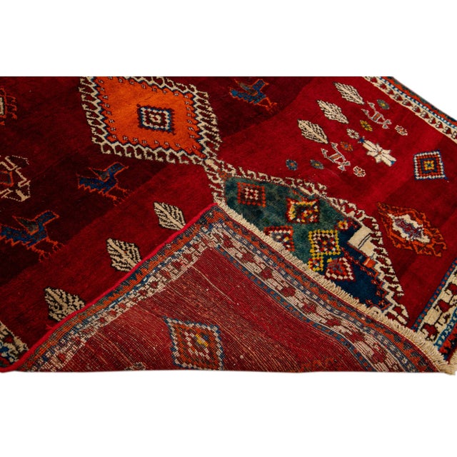 Beautiful Antique Persian Shiraz Handmade Wool rug with an all-over red field. This piece has multi-color accents in a...