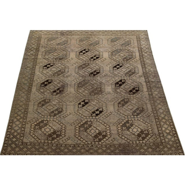 Beautiful antique Turkmen hand-knotted wool rug with a light brown color field. This Persian piece has a gorgeous Gul...