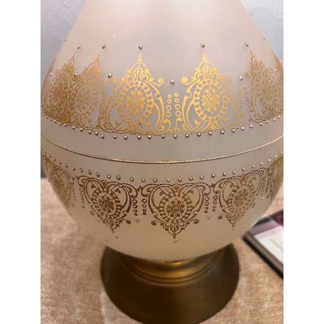 A showstopper of a lamp. This vintage frosted glass table lamp features an elegant genie bottle silhouette with hand-...