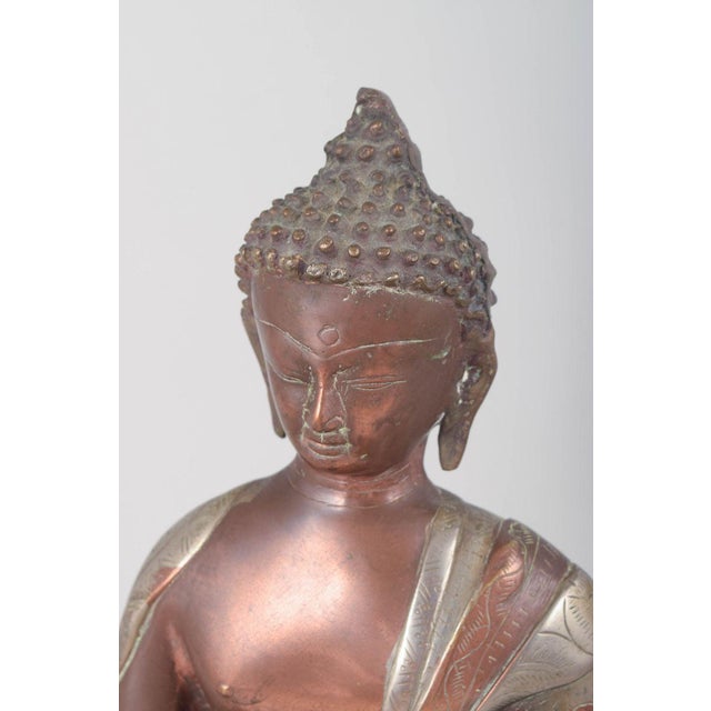 Large bronze Buddha figure. Large seated Buddha figure executed in patinated bronze with a serene facial expression,...