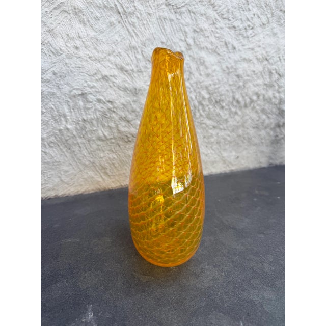 Hand blown yellow glass vase with white cane webbing made by John Gecei. The artist initials is incised on the bottom of...