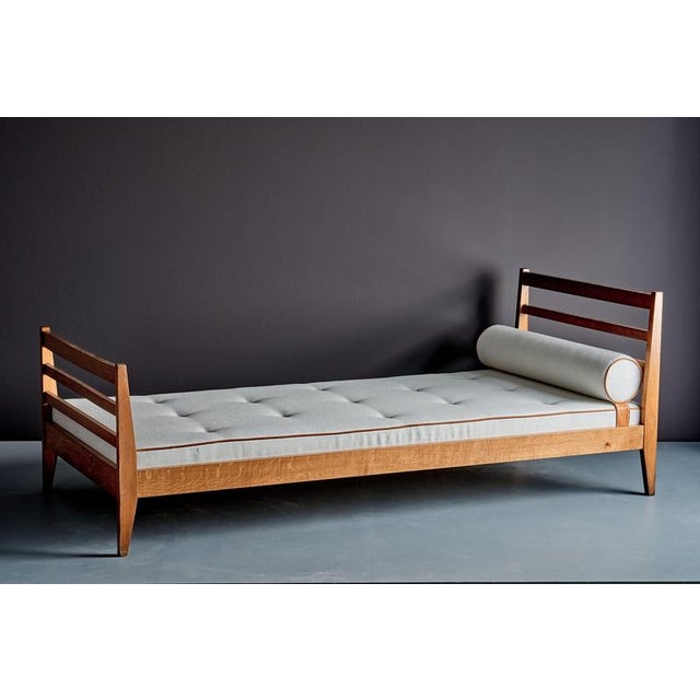 French daybed from the 1940s, made of solid oak with a simple, architectural design. Newly upholstered with a tufted seat...