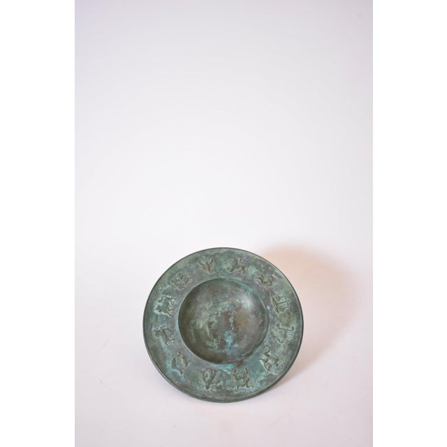 Circular neoclassical bronze plate, 1940s. Height: 3 cm - 1.18 in Diameter: 27 cm - 10.63 in