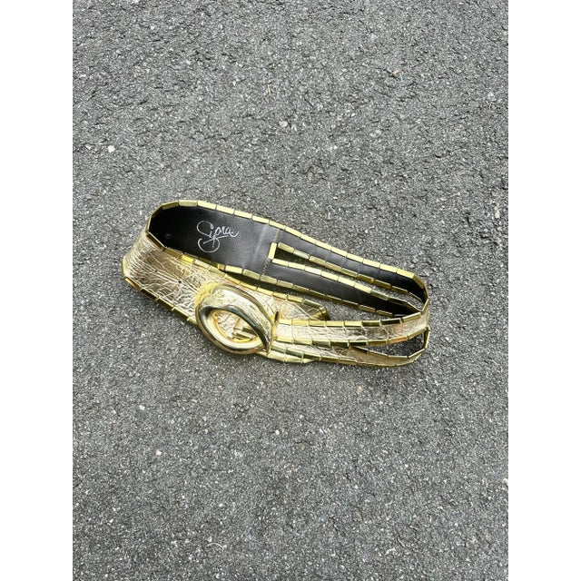 1980s gold leather Supra belt with large gold oval buckle.