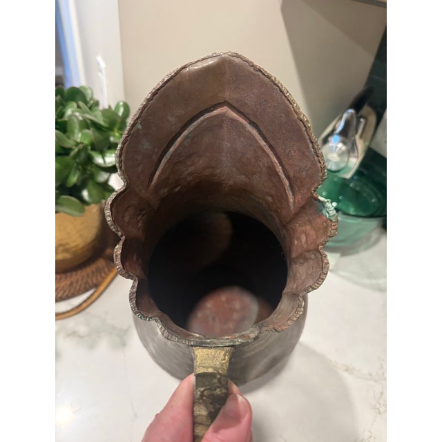 A striking hand-hammered copper pitcher in the Middle Eastern or Turkish tradition, likely dating to the late 19th or...