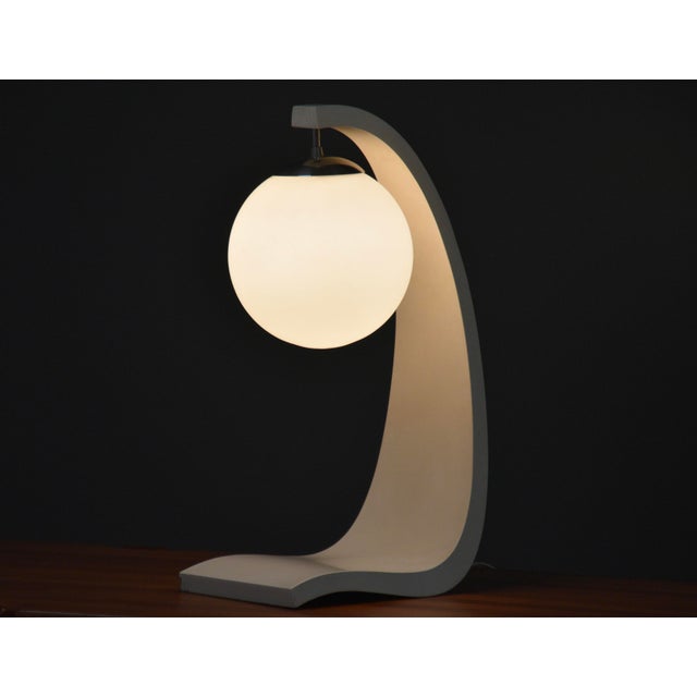 A mid century modern white Serpentine table lamp designed by Jack Hayward for Modeline of California. Glass globe in tact....