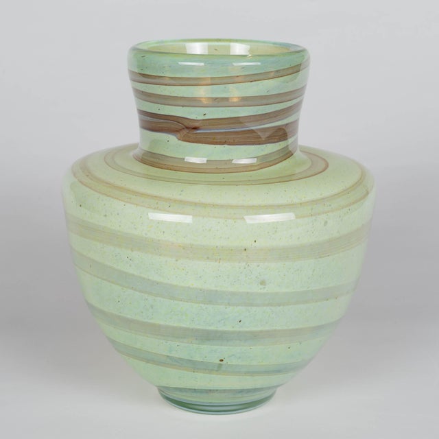 A vintage Mdina art glass vase handcrafted in Malta featuring characteristic sea foam green color with earth toned banded...