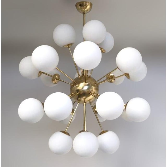 Italian sputnik chandelier with 24 matte white Murano glass globes mounted on brass frame in unlacquered natural brass...