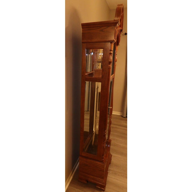 A refined American-made grandfather clock by Ridgeway, model 9109, crafted in the early 1990s and presented in a warm oak...