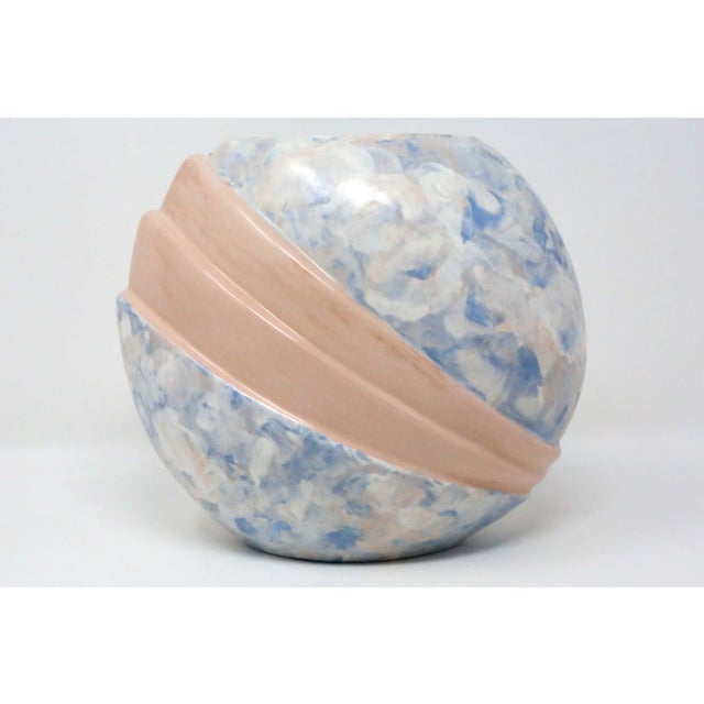 A vintage 1950's/60's ceramic vase, with a rounded, pleated form and art deco style, painted with a blue, pink and white...