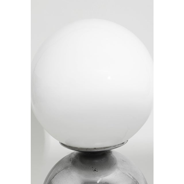 Polished chrome sphere anchored by a luminous glass globe. Lamp is in working condition. Wired with a European plug; an...