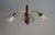 Three-light chandelier with three brass arms on a gilt bronze base, featuring floral motifs. Shades are made of lightly...