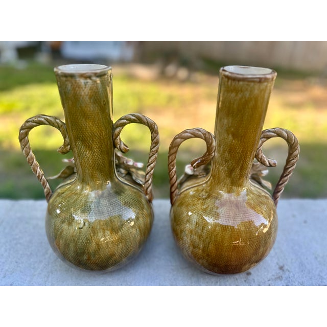 This is a pair of antique French Art Nouveau barbotine majolica vases, featuring applied and hand painted pink flowers and...