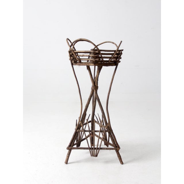 This antique Adirondack twig planter table features a twig tripod frame and a basket top. MEASUREMENTS Height: 29" ......