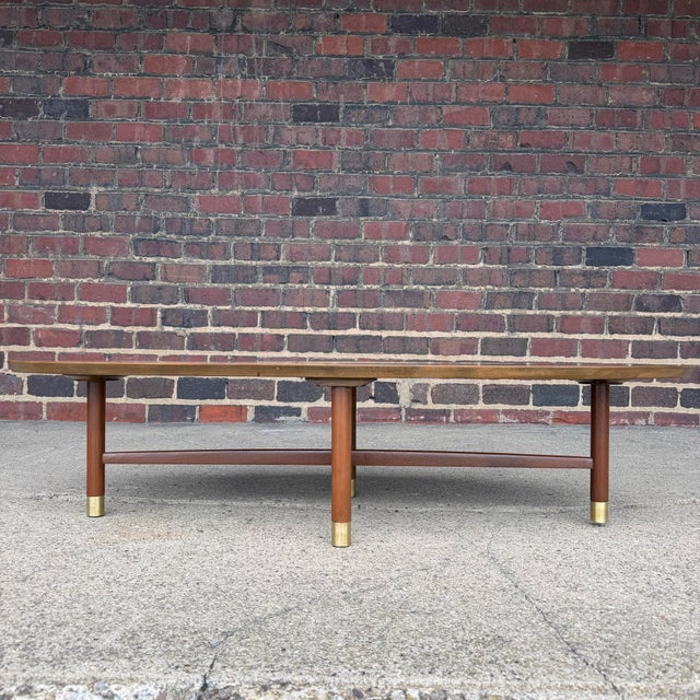 This is a beautiful professionally refinished walnut coffee table. It features an oval or surfboard shape, timeless design...