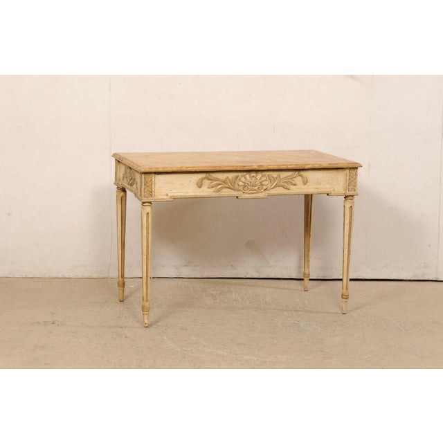 A French carved console table, with its original painted finish, from the early 20th century. This antique table from...