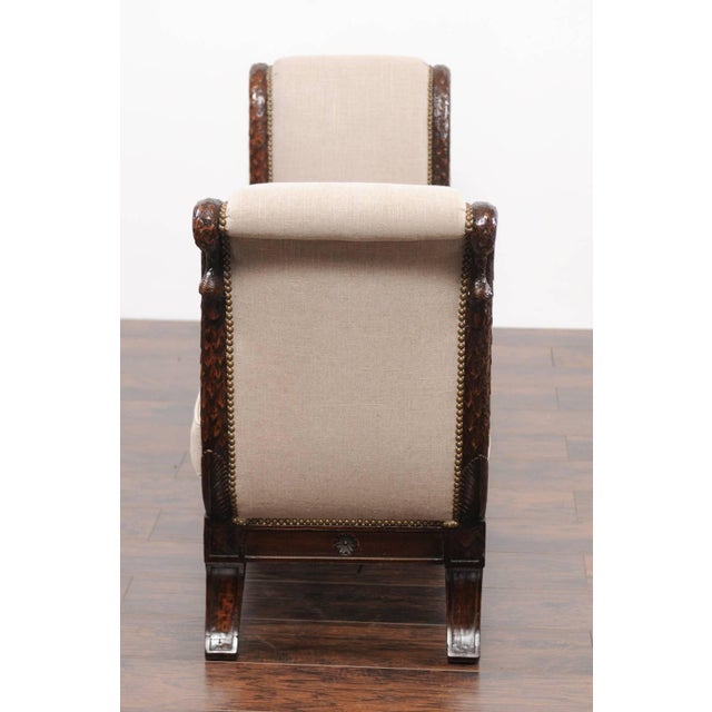 A French Empire style walnut bench from the mid-19th century, with carved swan heads and new upholstery. This French...