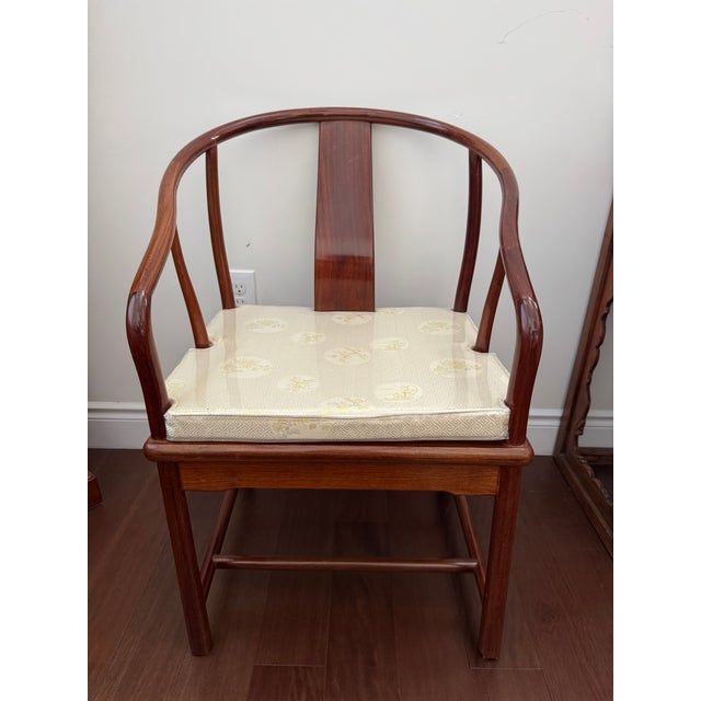 An elegant Chinese Ming-style horseshoe-back armchair featuring a continuous curved crest rail, gently shaped arms, a...