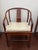 An elegant Chinese Ming-style horseshoe-back armchair featuring a continuous curved crest rail, gently shaped arms, a...