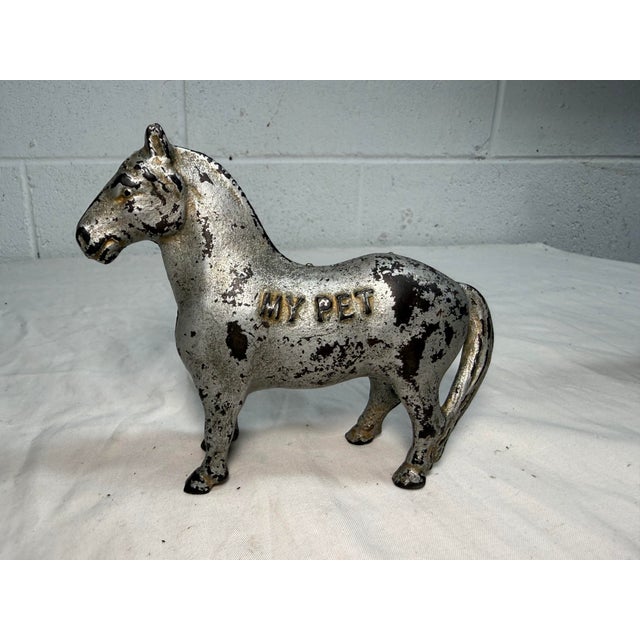This rare antique 1905 manufactured Cast Iron "My Pet" still bank by Arcade is a unique and collectible piece with an...