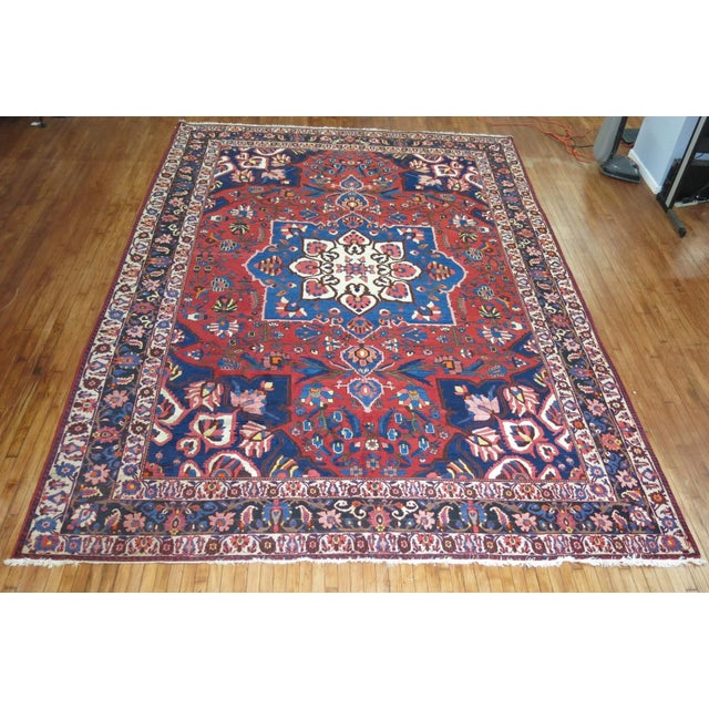 A mid 20th Century oversize persian Bakhtiari rug in traditional colors. This piece is a true vintage, one of a kind rug...