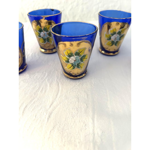 Beautiful mid-century cobalt blue Italian Murano glass cordial/shot glasses featuring 24K gold embellishments with raised...