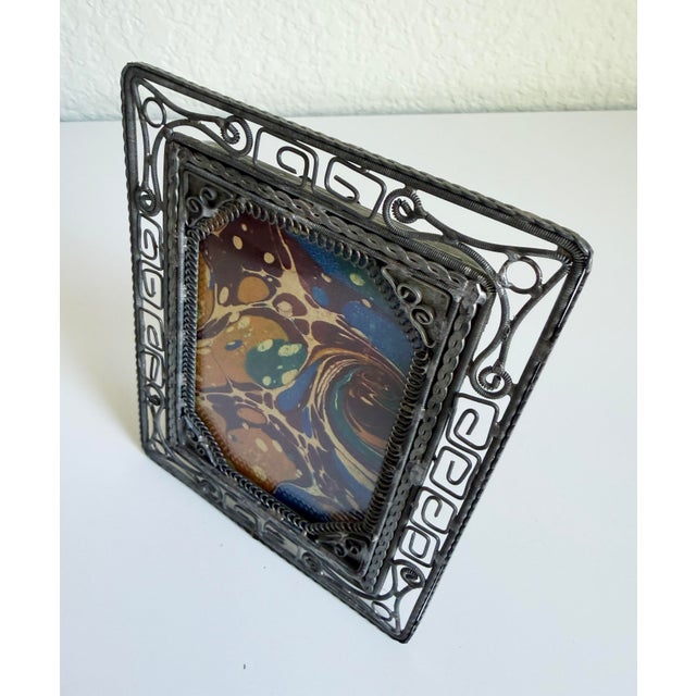 Unique early-1900s picture frame made of delicately bent and wound pewter-toned wire. Includes the original glass and blue...