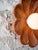 A sculptural wall sconce hand-carved from a single block of natural red travertine. Soft, rounded petals frame a frosted...