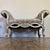 Stunning vintage bench featuring an ornate Rococo Revival design with dramatic scroll arms, cabriole legs, and carved...