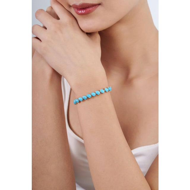 This statement tennis bracelet showcases 16.14 carats of natural pear-cut cabochon turquoise, set in rich 18k yellow gold....