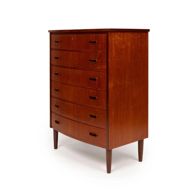 A masterful example of Danish Mid-Century Modern design, this 1960s teak tallboy dresser embodies the harmony of form,...