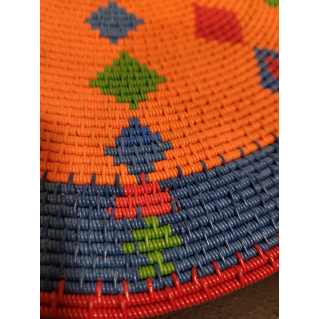 This saucer-shaped bowl, is from a gallery design with brightly coldored and hand woven fibers. African folk art wall...