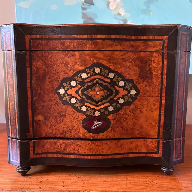 A lovely Napoleon III liquor cabinet with burlwood case with inlaid mother of pearl and brass detailing. The set includes-...