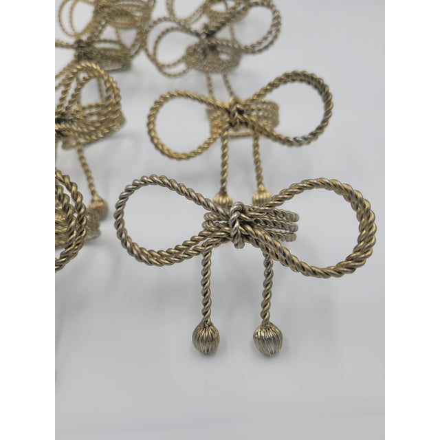 Elevate your tablescape with this stunning set of eight vintage Hollywood Regency-style napkin rings. Crafted from gold-...