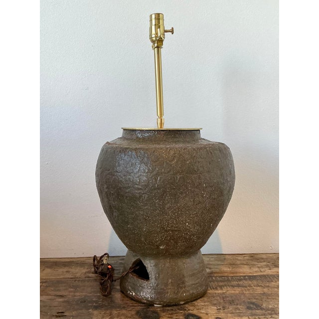 Exuding a soulful, wabi-sabi aesthetic, this vintage Thai Martaban pottery lamp is a masterclass in organic texture and...